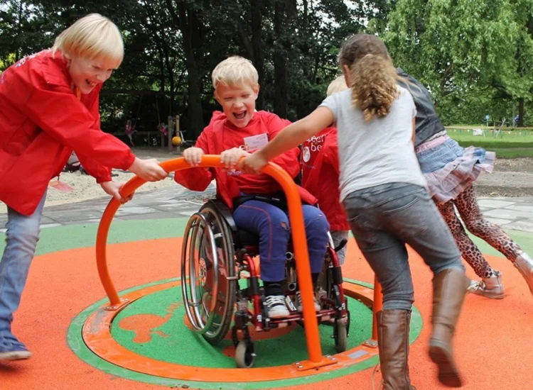 Kinder mit und ohne Rollstuhl auf einem Karussell beim spielen.