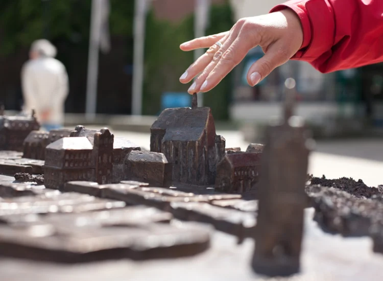 Hand berührt Bronzeguss-Modell der Stadt